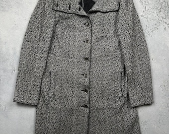 May include: A gray and white herringbone pattern coat with a button-up front and a wide collar. The coat has long sleeves and a tailored fit, suitable for cooler weather. The coat is made of a woven fabric.