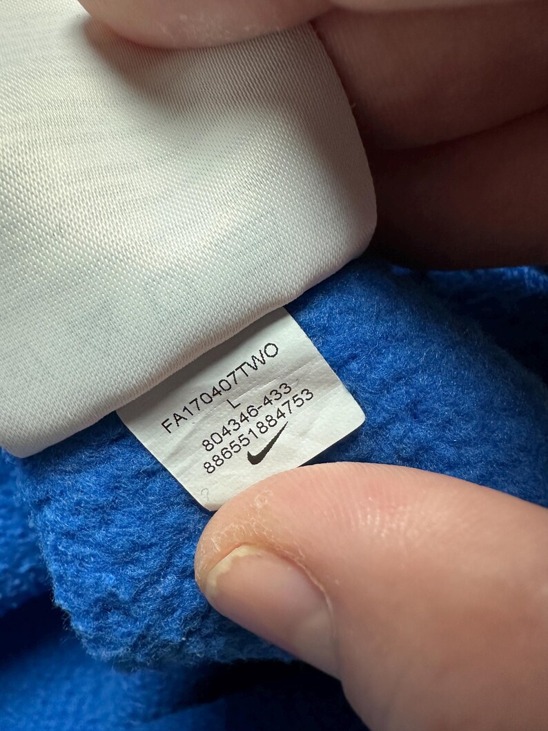 Peut inclure: Une &eacute;tiquette blanche avec du texte noir et un logo Nike swoosh. L'&eacute;tiquette indique "FA170407T7WO L 804346-433 8866551884753".