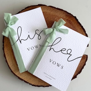 Può includere: Due libretti per i voti bianchi e testurizzati con testo in corsivo nero his vows e her vows. Ogni libretto è legato con un nastro sfilacciato color verde salvia. Il secondo libretto riporta i nomi Amelia & Benjamin e la data 22.08.2026.