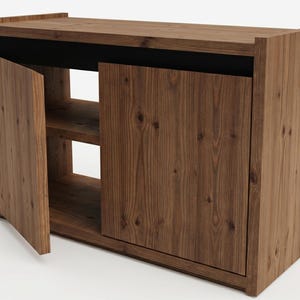 May include: A rectangular wooden cabinet featuring a natural brown wood grain finish. The unit has a flat top surface, a solid side panel, and two front doors. One door is partially open, revealing an interior shelf and a black horizontal accent.