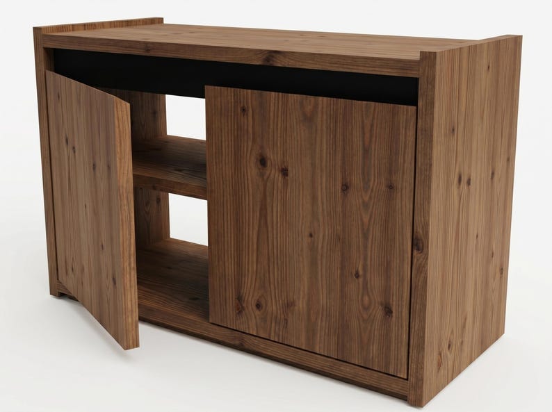 May include: A rectangular wooden cabinet featuring a natural brown wood grain finish. The unit has a flat top surface, a solid side panel, and two front doors. One door is partially open, revealing an interior shelf and a black horizontal accent.