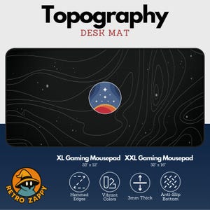 May include: Black desk mat with white topographical lines and a circular graphic of a starry sky over a red and orange planet. The mat is labeled "Topography DESK MAT" and is available in XL (22" x 12") and XXL (32" x 16") sizes.