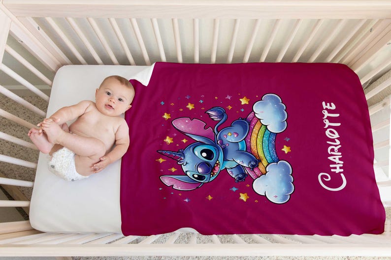 May include: A pink fleece blanket with a blue Stitch character riding a rainbow unicorn. The blanket has a white border and the name "Charlotte" is printed on the right side.