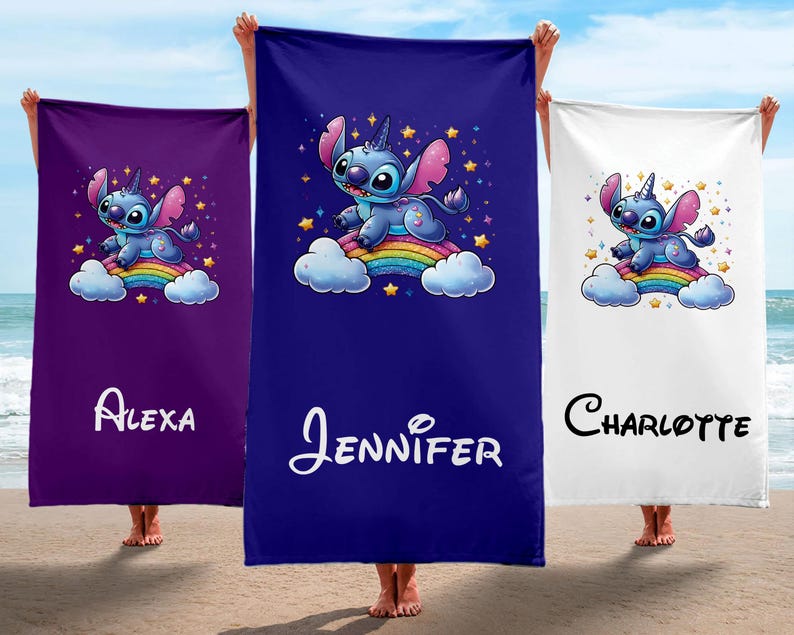 May include: Three beach towels with a blue Stitch character riding a rainbow. The towels are purple, blue, and white. The names Alexa, Jennifer, and Charlotte are printed on the towels.