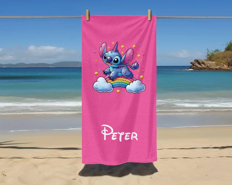 May include: Pink beach towel with a blue Stitch character riding a rainbow. The towel has the name "Peter" printed on it.