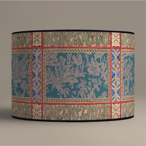 May include: Cylindrical lampshade with a teal background featuring a pastoral scene in pink and white. The shade is framed with red, gold, and blue accents, and a dark blue trim.