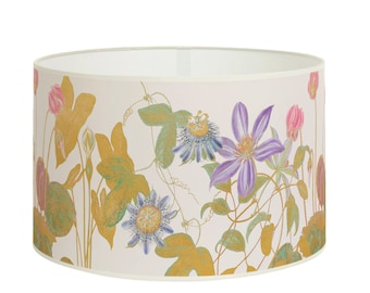 Può includere: Un paralume bianco con un motivo floreale con fiori viola, rosa e blu con foglie verdi e dettagli dorati.