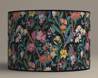 Può includere: Un paralume nero con un motivo floreale con fiori rosa, gialli, blu e verdi su uno sfondo scuro.