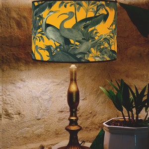 Bold yellow lampshade with detailed blue bird artwork