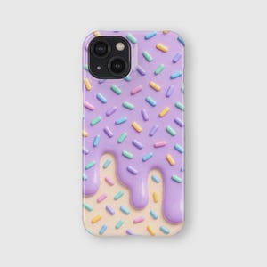 May include: A rectangular smartphone case featuring a light purple drip pattern over a light beige background. The surface is covered in small, cylindrical sprinkles in shades of yellow, light blue, and pink, creating a textured appearance.