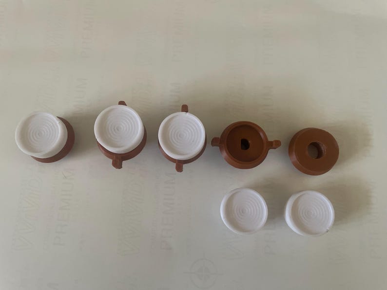 May include: Seven brown and white plastic buttons with a raised centre. The buttons are circular and arranged in a row.