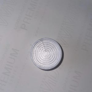 May include: A white circular object with concentric circles, resembling a target or a bullseye.