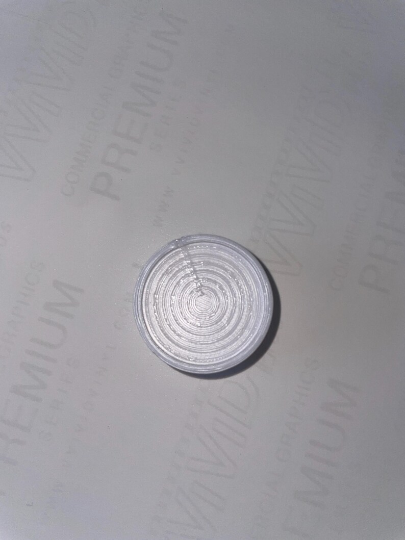 May include: A white circular object with concentric circles, resembling a target or a bullseye.