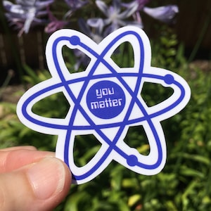 May include: A white sticker with a blue atom symbol and the text "you matter" inside a circle in the center.
