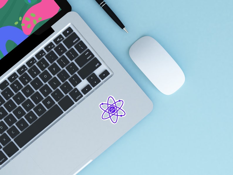 May include: A silver laptop computer with a black keyboard and a purple atom sticker on the top right corner. A white wireless mouse and a black pen are on the light blue surface.