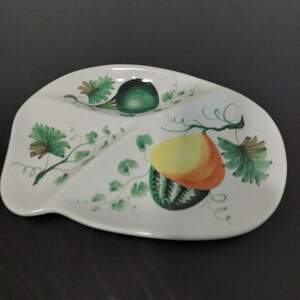 May include: A white ceramic serving dish with three sections. The dish is decorated with hand-painted green vines, leaves, and gourds.