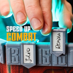 Könnte beinhalten: Ein grauer Initiative-Tracker aus Kunststoff für Brettspiele mit dem Text SPEED UP COMBAT. Der Tracker verfügt über nummerierte Schlitze mit weißen rechteckigen Einsätzen, die mit den Namen Julio und Remissa in schwarzer Tinte beschriftet sind.