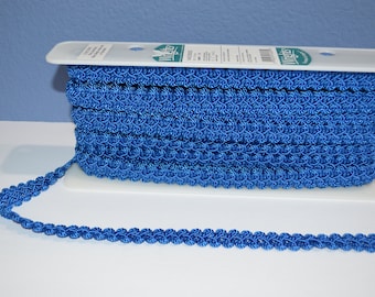 May include: A spool of blue trim with a scalloped edge. The trim is wound around a white plastic spool with a label that reads "Wrights".