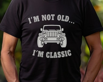 Puede incluir: Un hombre con una camiseta negra con un gráfico blanco de un jeep y el texto "I'm not old... I'm classic".