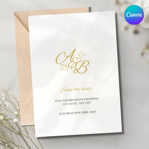 May include: A white save the date card with gold lettering. The card features the initials "A & B" with stylized doves. The text reads "Save the date", "Anna and Brandon's Wedding", "Any State, Any City", and "Saturday 19th April 2025".