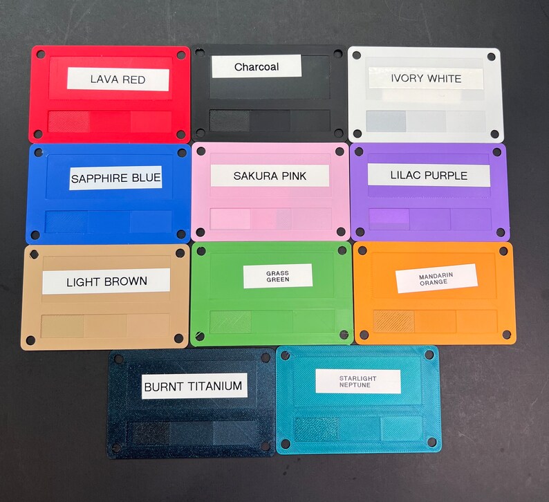 May include: Ten color swatches on rectangular plastic cards with rounded corners. The colors are: Lava Red, Charcoal, Ivory White, Sapphire Blue, Sakura Pink, Lilac Purple, Light Brown, Grass Green, Mandarin Orange, Burnt Titanium, and Starlight Neptune.