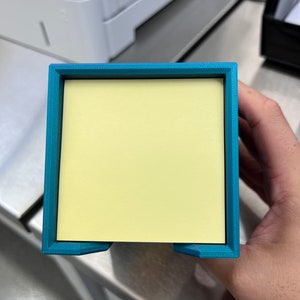 May include: A teal blue plastic desk organizer with a yellow sticky note dispenser.