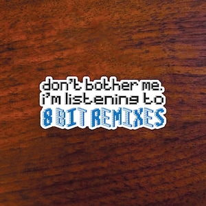May include: White sticker with black text that reads "don't bother me. i'm listening to 8 BIT REMIXES". The text is in a pixelated font, and the word "REMIXES" is in blue.