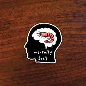 May include: A black and white sticker of a human head with a shrimp inside the brain. The text "mentally krill" is below the head.