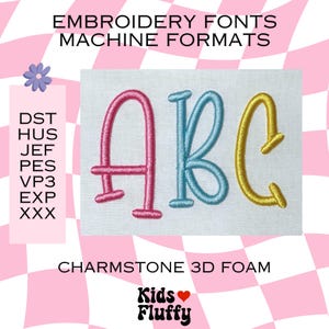Peut inclure: Image présentant des polices de broderie en formats machine. Les lettres "ABC" sont brodées en fil rose, bleu et or. Le texte "EMBROIDERY FONTS MACHINE FORMATS" et "CHARMSTONE 3D FOAM" sont visibles, ainsi que le logo "Kids Fluffy".