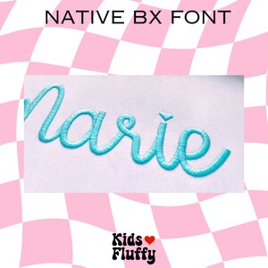 Pu&ograve; includere: Primo piano della parola "marie" ricamata in filo blu chiaro su uno sfondo di tessuto bianco. Il testo &egrave; in un font corsivo.