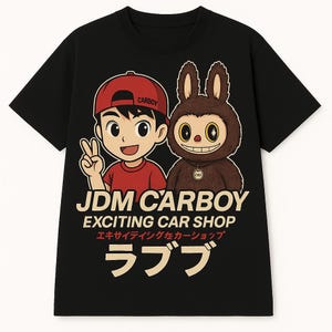 May include: Black t-shirt featuring a cartoon illustration of a boy and a furry creature. The boy wears a red cap and shirt, giving a peace sign. The text "JDM CARBOY" and "EXCITING CAR SHOP" are printed below the characters.