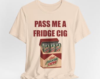 Puede incluir: Camiseta beige con la frase "PASS ME A FRIDGE CIG" en granate. Debajo, un gráfico de una caja de Diet Mountain Dew con tres latas dentro. La caja es de color beige con detalles granates y el logotipo de Diet Mountain Dew.