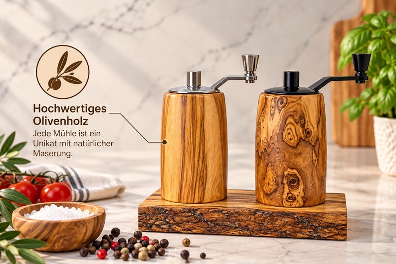 K&ouml;nnte beinhalten: Zwei zylindrische Gew&uuml;rzm&uuml;hlen aus Olivenholz mit Metallkurbeln, eine mit silberfarbenem und eine mit schwarzem Aufsatz. Sie stehen auf einem rechteckigen Olivenholzbrett mit nat&uuml;rlicher Baumkante und ausgepr&auml;gter Maserung.