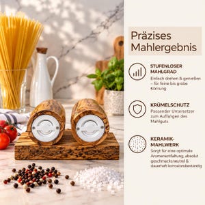 K&ouml;nnte beinhalten: Zwei Salz- und Pfefferm&uuml;hlen aus Olivenholz mit wei&szlig;em Keramikmahlwerk auf einem passenden Holzsockel. Der Text rechts beschreibt die Funktionen: stufenloser Mahlgrad, Kr&uuml;melschutz durch Untersetzer und ein langlebiges Keramikmahlwerk.