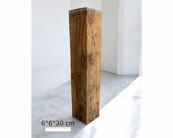 May include: A tall, rectangular wooden pillar with a natural wood grain pattern. The pillar is 6 x 6 x 11.8 inches. The wood has a warm, brown tone, and the surface appears smooth. The pillar stands upright against a white background.