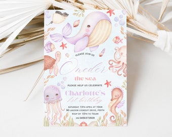 May include: A light blue and pink invitation card with a watercolor illustration of a whale, jellyfish, octopus, seahorse, and turtle. The text on the card reads "Please join us Oneder the sea Please help us celebrate Charlotte's 1st birthday Saturday 13th April at 10am 90 Lagoon Lookout Drive, Perth RSVP by 10th to Tegan on 0456372828"