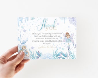 May include: Thank you card with a blue and white watercolor design featuring fairies and flowers. The text reads "Thank you for coming to celebrate Evelyn's 2nd birthday with us! She had a wonderful time creating some beautiful memories with you. With love the belly."