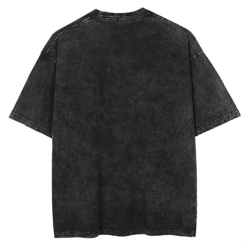 Puede incluir: Una camiseta negra de manga corta con un aspecto texturizado y lavado. La camiseta tiene cuello redondo y un corte relajado. La tela tiene un aspecto moteado y descolorido, lo que le da una est&eacute;tica vintage o desgastada. El estilo general es casual y vers&aacute;til.