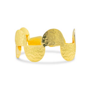 Può includere: Bracciale in metallo martellato dorato con un design ondulato. Il bracciale è composto da diversi pezzi collegati che formano un motivo a onda continuo.