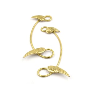 May include: Four gold-colored metal angel wing charms with loops. The wings are attached to a curved wire.