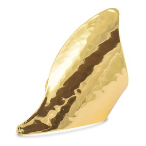 May include: A gold hammered metal ring with a unique, asymmetrical design. The ring is open and has a pointed tip.