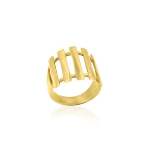 Könnte beinhalten: Ein goldener Ring mit einem geometrischen Design mit fünf vertikalen Balken.