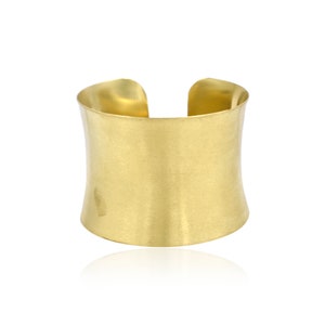 Op de afbeelding: Een gouden metalen armband met een glad, licht gebogen oppervlak.