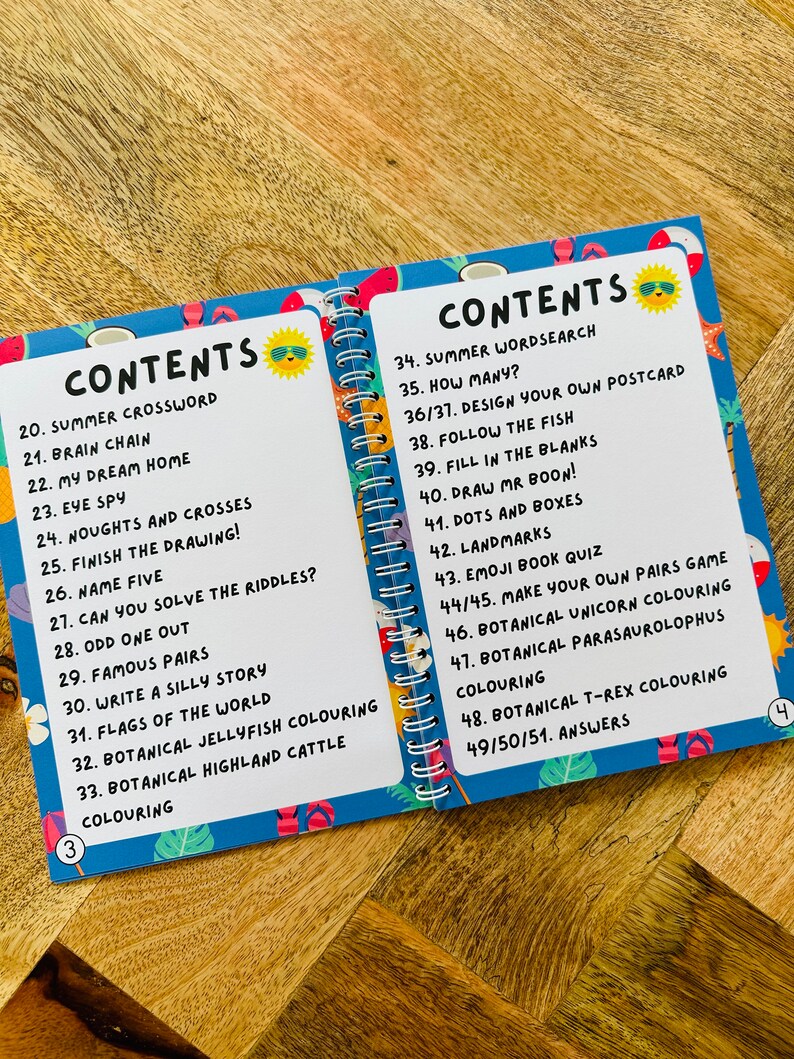 May include: A blue and white book with a colorful cover featuring a smiling sun wearing sunglasses. The book is titled "Contents" and lists activities for kids, including summer crossword, brain chain, eye spy, and more.