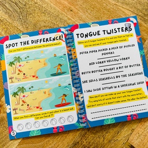 May include: A colorful children's activity book with a spot the difference game on the left page and tongue twisters on the right page. The left page features a beach scene with palm trees, an umbrella, and people. The right page features a blue background with white text.