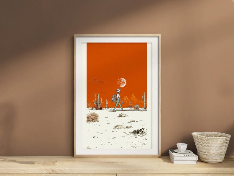 Framed poster resting on a taupe wall shelf with soft ceramic accents and natural lighting, highlighting the desert colors and clean linework.