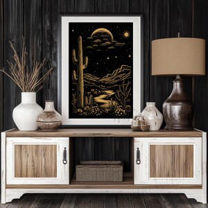 The print displayed on a dark wood-paneled wall above a two-tone rustic console table with a ceramic vase and modern lamp.