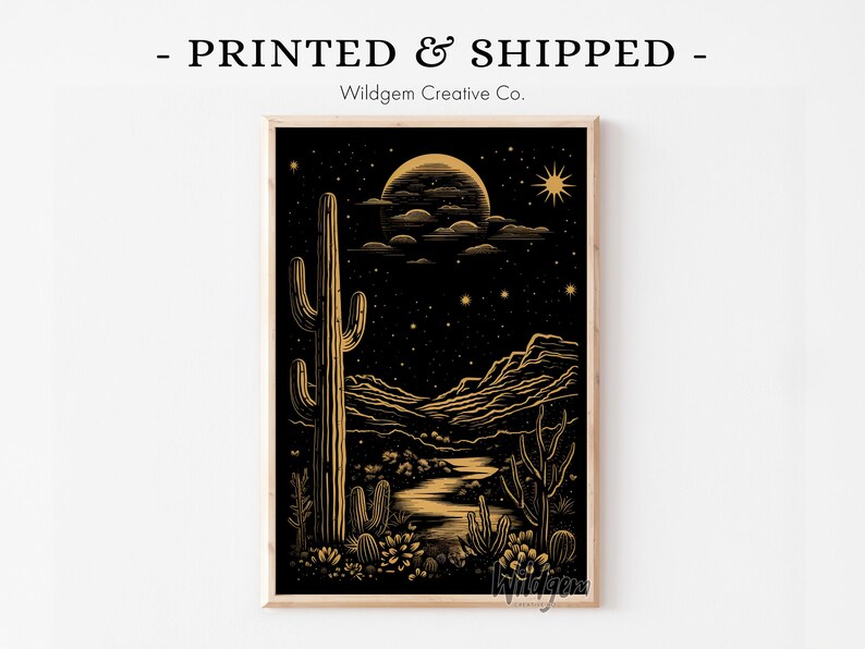 Framed black and gold western cactus print featuring a bold saguaro under a glowing moon and starry sky, displayed on a white wall with “PRINTED & SHIPPED – Wildgem Creative Co.” above.