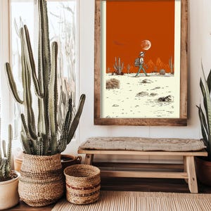 A woman seated cross-legged on a bed holding the framed Boho Skeleton Poster, styled in a warm, earthy bedroom with soft lighting and boho decor.