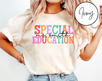 May include: A white t-shirt with the text "SPECIAL EDUCATION" in rainbow colors. The text "ms. smith" is in black and is smaller than the other text.